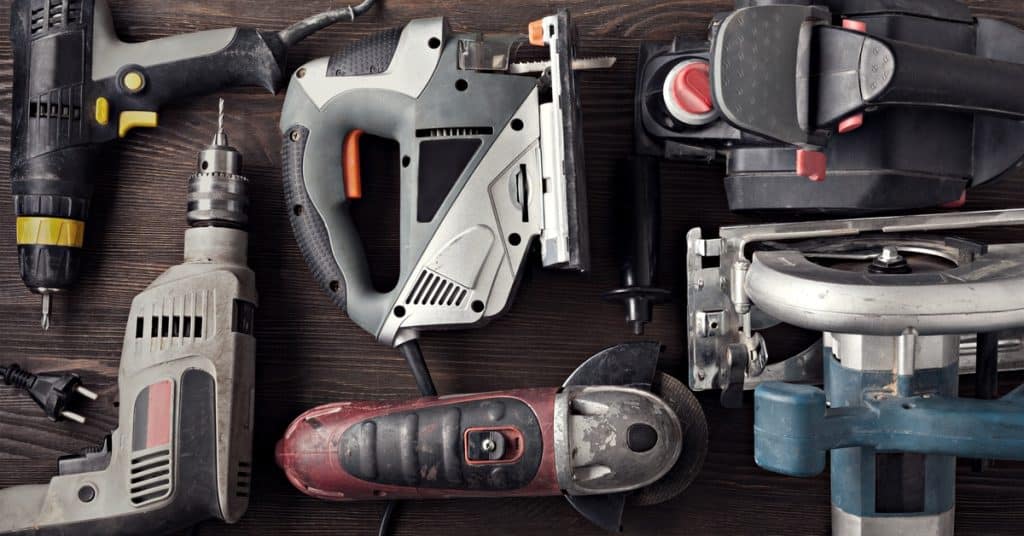 A close-up of a table with various power tools. The table includes drills, circular saws, and other related items.